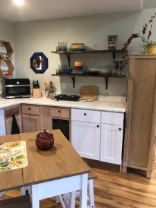 尤金Leos Loft的厨房配有白色橱柜和木桌