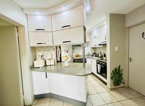 德班Makwande Self-Catering Apartment的厨房配有白色橱柜和台面