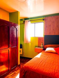 波托西HOSTAL SAN MARCOS POTOSÍ的一间卧室设有一张大床和一个窗户。