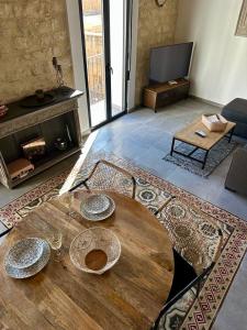 阿利坎特VillaVieja17 Studio-Apartments的客厅配有木桌和壁炉