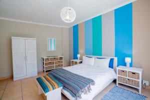 开普敦The Avenue House的一间卧室配有一张带蓝色墙壁的大床