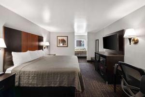 格罗夫城贝斯特韦斯特行政酒店的配有一张床和一台平面电视的酒店客房