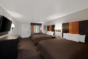 格罗夫城贝斯特韦斯特行政酒店的酒店客房设有两张床和一台平面电视。