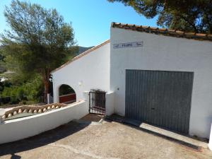 OrbaVilla Paloma的一座白色的建筑,设有大门和车库