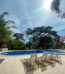雅科Dream Site near Punta Leona的一组椅子坐在游泳池旁