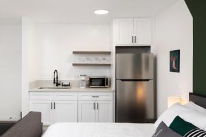 洛杉矶Fenix Hotel Hollywood的厨房配有白色橱柜和不锈钢冰箱