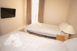 蒂斯河畔斯托克顿Norton Serviced Apartments的酒店客房设有两张床和一台平面电视。