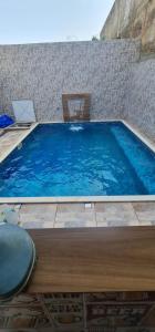 博伊图瓦Casa com piscina em boituva的一个带桌椅的大型蓝色游泳池