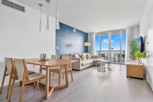 好莱坞Panoramic views 1 bed Beach Walk 27th Miami的客厅配有桌子和沙发