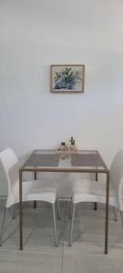 圣何塞德尔卡沃Estudio Biznaga的一张带白色椅子和照片的餐桌