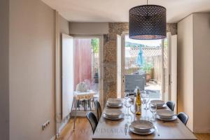 吉马良斯Casa Porta Nova AL的一间带桌椅的用餐室和一间带窗户的房间