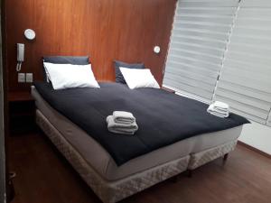 乌尤尼昂克尔乌尤尼旅行胶囊旅馆的客房内的一张床位,上面有毛巾