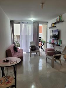 辛塞莱霍Apartamento Tranquilo para Descansar的客厅配有粉红色的沙发和椅子