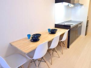 端岛Guest House Gifuhashima COCONE / Vacation STAY 33937的厨房配有木桌和白色椅子