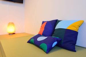 端岛Guest House Gifuhashima COCONE / Vacation STAY 33937的坐在台灯旁的地板上的一个彩色枕头