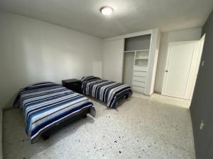 莱昂BaW Mateos 809P的一间卧室配有两张床和一个衣柜