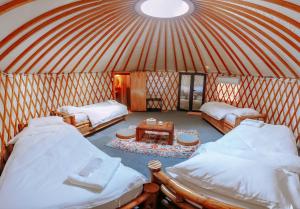 科隆Nomad Yurts的圆顶帐篷内带两张床和一张桌子的房间