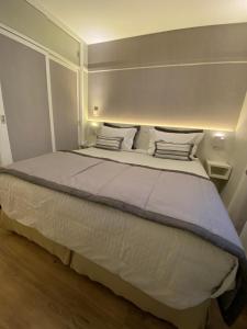 圣保罗Ninety Suíte Premium的卧室配有一张带白色床单和枕头的大床。