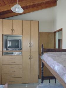 BarraqueroCasa Obrien的一间卧室配有一张床、一台电视和橱柜