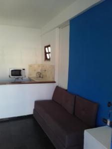 阿拉亚尔-杜卡布Santorini Flats的带沙发和蓝色墙壁的客厅