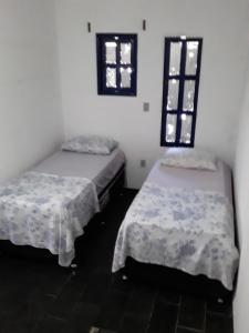 阿拉亚尔-杜卡布Santorini Flats的带两张床和两个窗户的房间