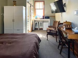 德卢斯Endion Inn的一间卧室配有一张床、一张书桌和一台电视。