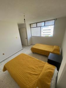 莱昂BaW Mateos 809P的一间卧室设有两张床和窗户。