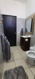 圣何塞德尔卡沃Casa Sol Descanso y Diversion的一间带卫生间、水槽和黑色门的浴室