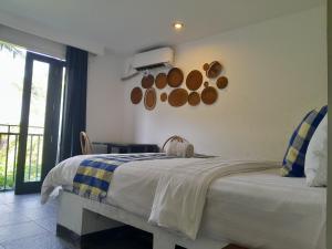 圣吉吉Taman Unique Hotel的一间卧室设有一张大床和一个窗户。
