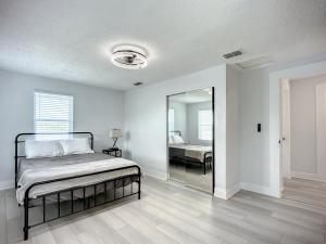 杰克逊维尔Trout River Oasis的白色卧室配有床和镜子