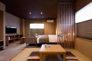 京都Rinn Kitagomon的一间卧室配有一张床、一张沙发和一张桌子
