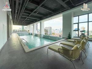 金边Prince Huan Yu Center Hotel & Residence太子寰宇中心酒店公寓的一座带椅子的游泳池和一座游泳池
