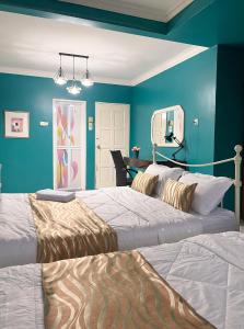 卢穆特Venice Raudhah Guest House的蓝色墙壁客房的两张床