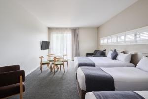 堪培拉甘加林 公寓的酒店客房设有两张床和一张桌子。