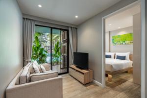 邦涛海滩Diamond Resort Phuket Official Account的一间卧室配有一张床、一台电视和一张沙发