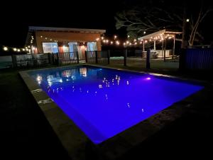 EwingsdaleSunset Cottage, Byron Bay的游泳池在晚上亮蓝色