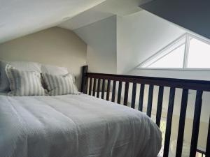 EwingsdaleSunset Cottage, Byron Bay的卧室配有带枕头的床铺和窗户。