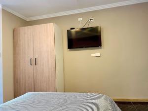 昆卡Suitesecu Cuenca的卧室配有一张床,墙上配有电视。