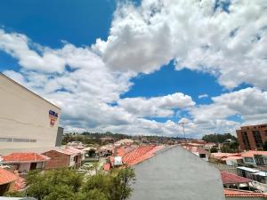 昆卡Suitesecu Cuenca的一座有建筑的城市,一片云 ⁇ 的蓝色天空