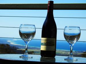 Saint Marys卢米拉生态山林小屋的桌子上放有一瓶葡萄酒和两杯酒