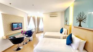 吉隆坡吉隆坡假日广场公寓的一间酒店客房,设有两张床和电视