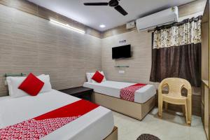 拉加蒙德里Hotel Vallabha Residency的一间酒店客房,设有两张床和电视
