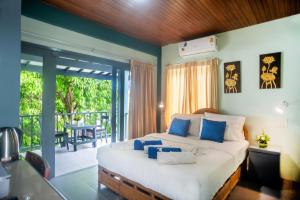 湄南海滩花店度假酒店的一间带大床的卧室和一个阳台