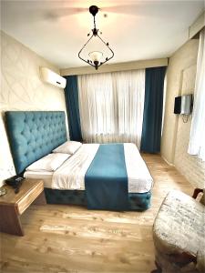埃利特温泉EVİM APART HOTEL的一间卧室配有一张蓝色床头板的大床