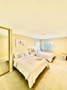 旧金山Stunning apartment steps from Ocean Beach的一间大卧室,配有两张床和镜子