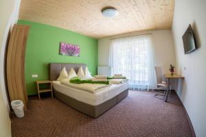 奥西阿赫格斯霍斯卡皮格/皮锐玛米亚酒店的一间卧室设有一张床和绿色的墙壁
