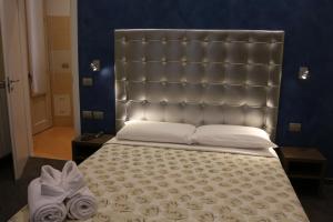 米兰拉玛尼纳酒店的卧室内一张带大床头板的大床