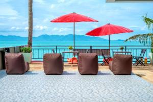 湄南海滩花店度假酒店的海滩上的一组椅子和遮阳伞