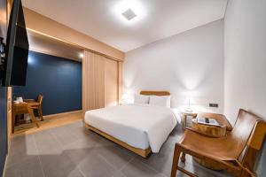釜山Hound Hotel Haeundae Signature的一间卧室配有一张床、一张书桌和一台电视。