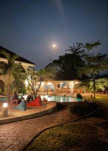 哲帕拉La Collina Villa的夜间带游泳池的度假村
